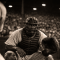 Baseball catcher in 1940s uniform crouches behind home plate at a packed Pittsburgh stadium, capturing the era when Josh Gibson was considered the greatest hitter in baseball.